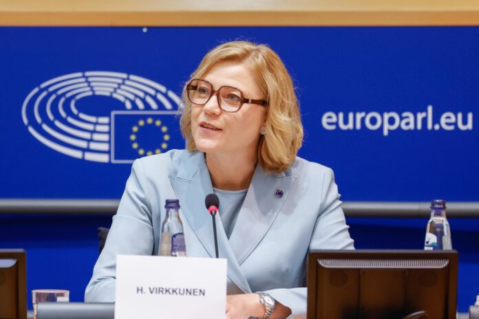 Henna Virkkunen seated behind her nameplate in front of a European Parliament backdrop